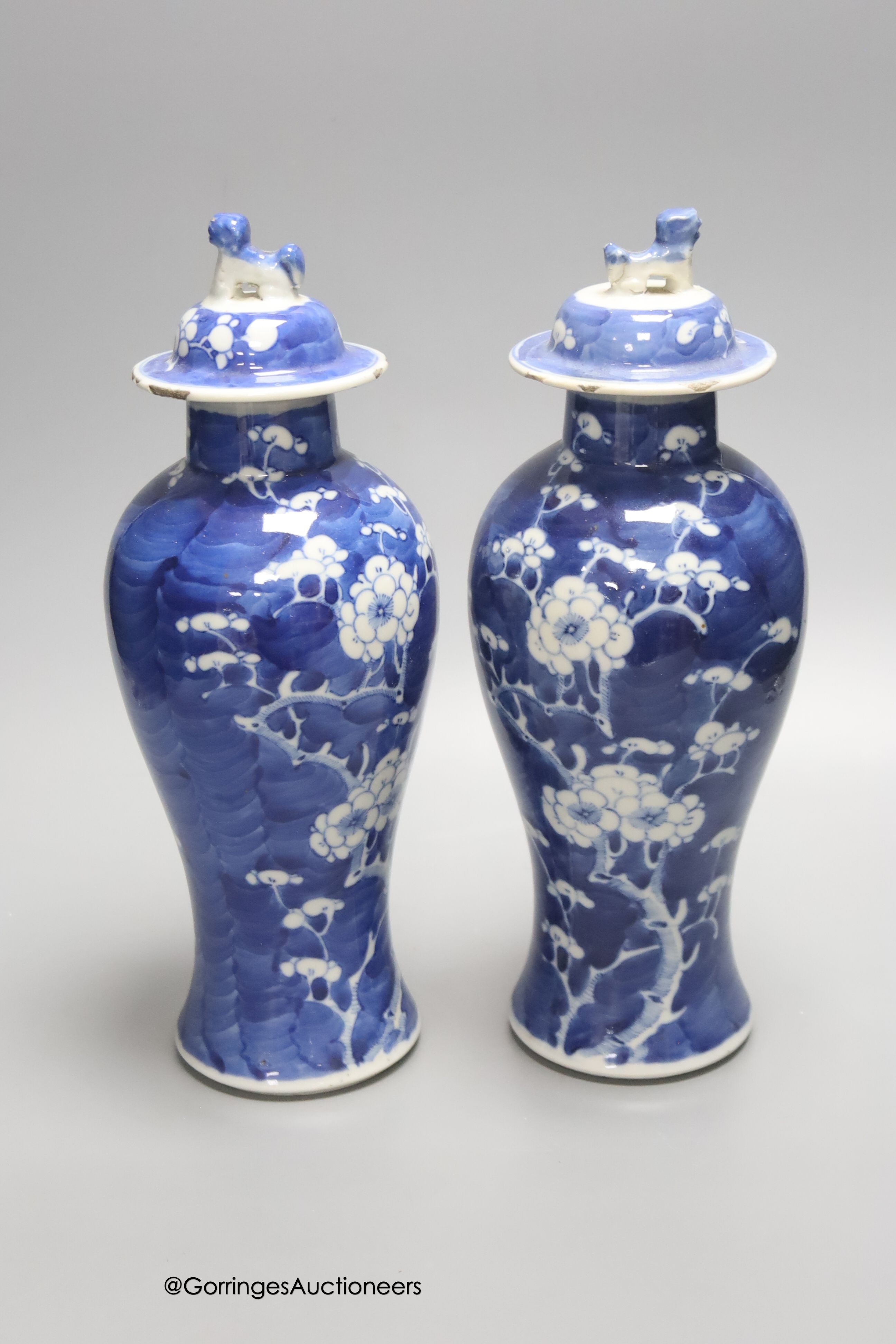 A pair of early 20th century Chinese blue and white prunus vases and covers, height 30cm